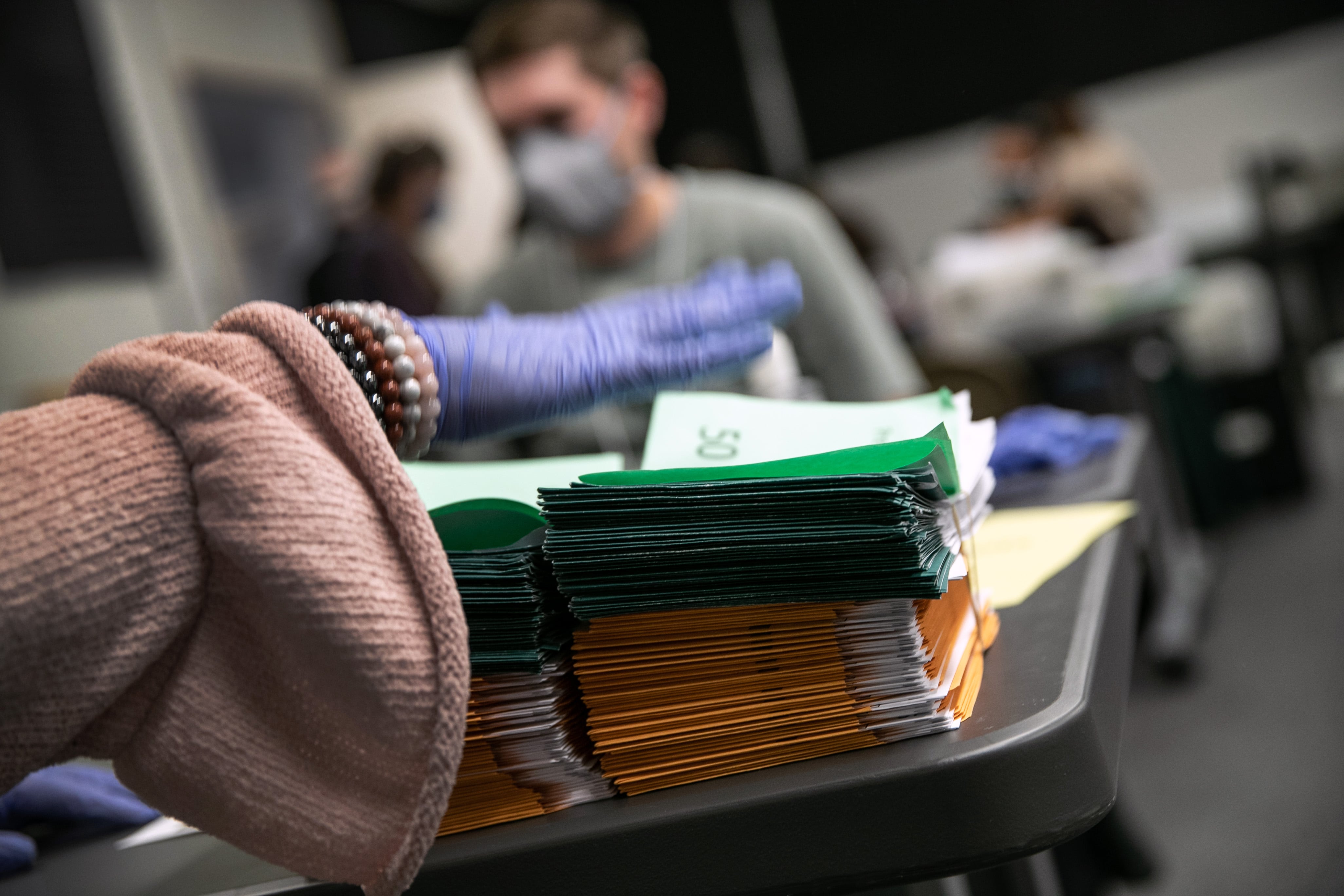 Election workers sort absentee ballot envelopes at the Lansing City Clerk's office on November 02, 2020 in Lansing, Michigan.