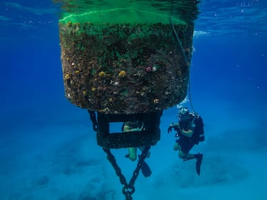 Steel Worker 3rd Class Andrew Cuellar, assigned to Underwater Construction Team (UCT) 2, Construction Dive Detachment Alfa, inspects a buoy within the Tinian Harbor on Oct. 1, 2020.