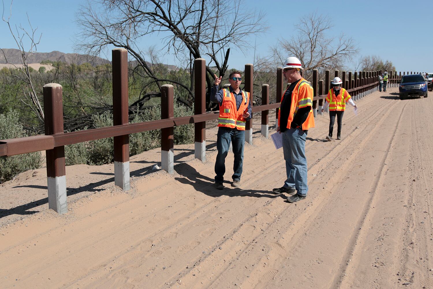 A team from the U.S. Army Corps of Engineers and contractors discuss Customs and Border Protection pedestrian border wall fencing requirements outside Yuma, Ariz., on April 11, 2019.