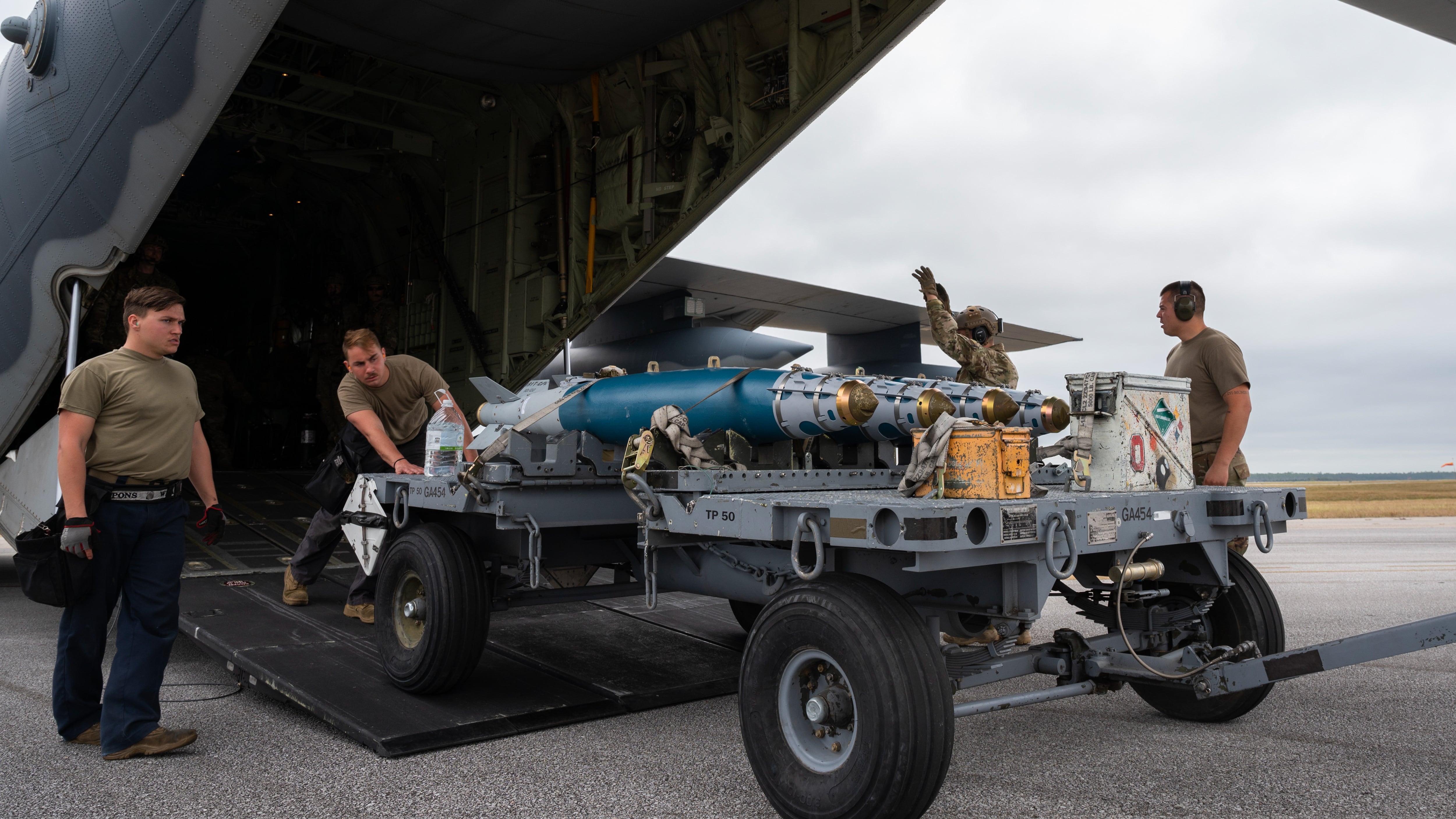 Airmen assigned to Air Force Special Operations Command and Air Combat Command offload a cart of GBU-38 joint direct attack munitions from an MC-130J Commando II assigned to the 9th Special Operations Squadron during Agile Flag 21-1 at Hurlburt Field, Florida, Oct. 27, 2020. Airmen assigned to AFSOC and ACC conducted a forward area refueling point operation and rearmed GBU-38s to two F-15E Strike Eagle assigned to the 389th Fighter Squadron, displaying the forces ability to be adaptable, survivable, and combat-ready for combatant commanders in the future. (Staff Sgt. Joseph Pick/Air Force)