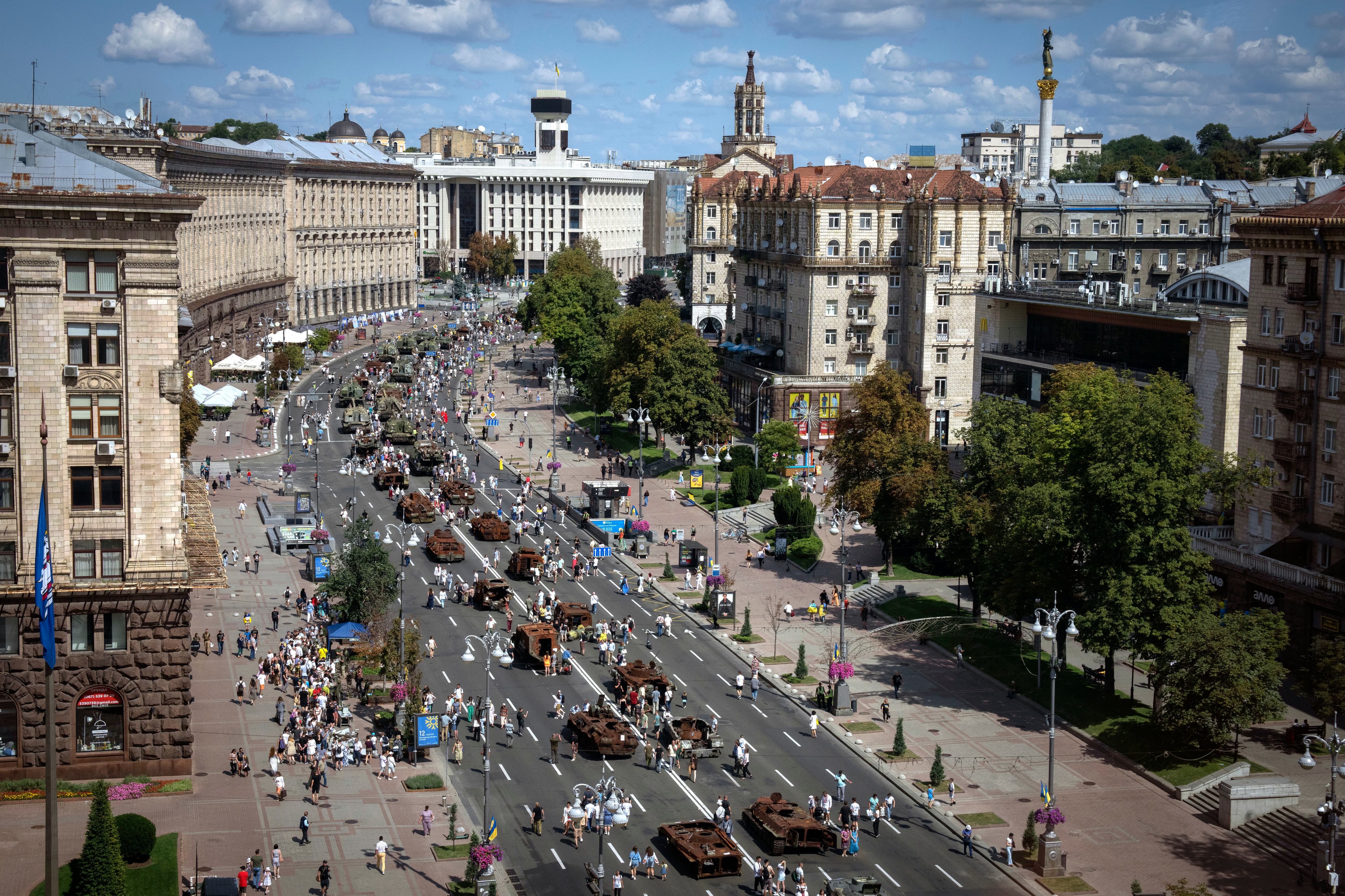 People look at a large column of burnt out and captured Russian tanks and infantry carriers which have been on display on the central Khreshchatyk boulevard as Ukrainians mark Independence Day, in Kyiv, Ukraine, Thursday, Aug. 24, 2023.