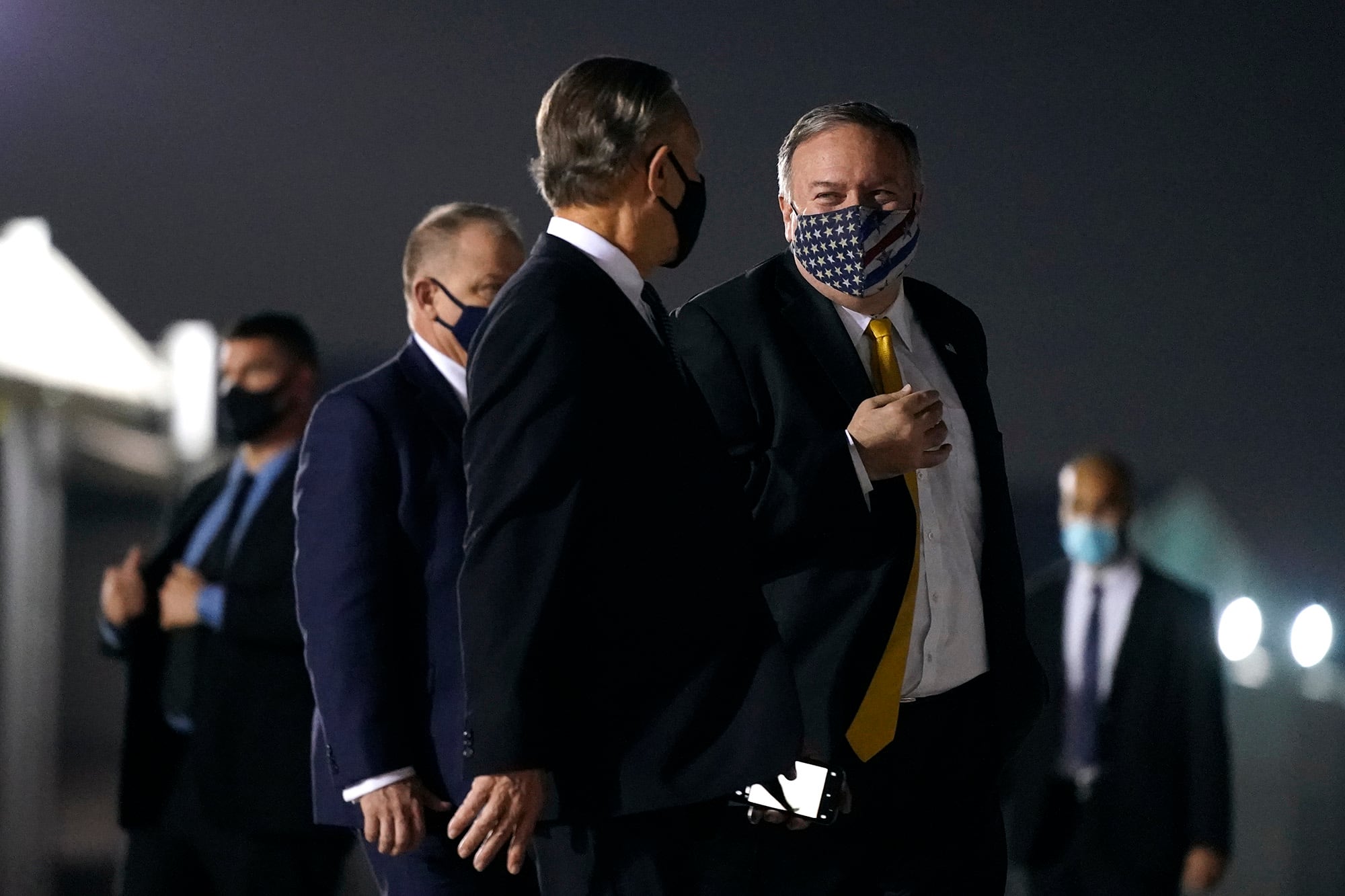 Secretary of State Mike Pompeo, center right, speaks with U.S. Ambassador to the United Arab Emirates John Rakolta before boarding a plane at Al Bateen Executive Airport in Abu Dhabi, United Arab Emirates, Sunday, Nov. 22, 2020. Pompeo is en route to Saudi Arabia.