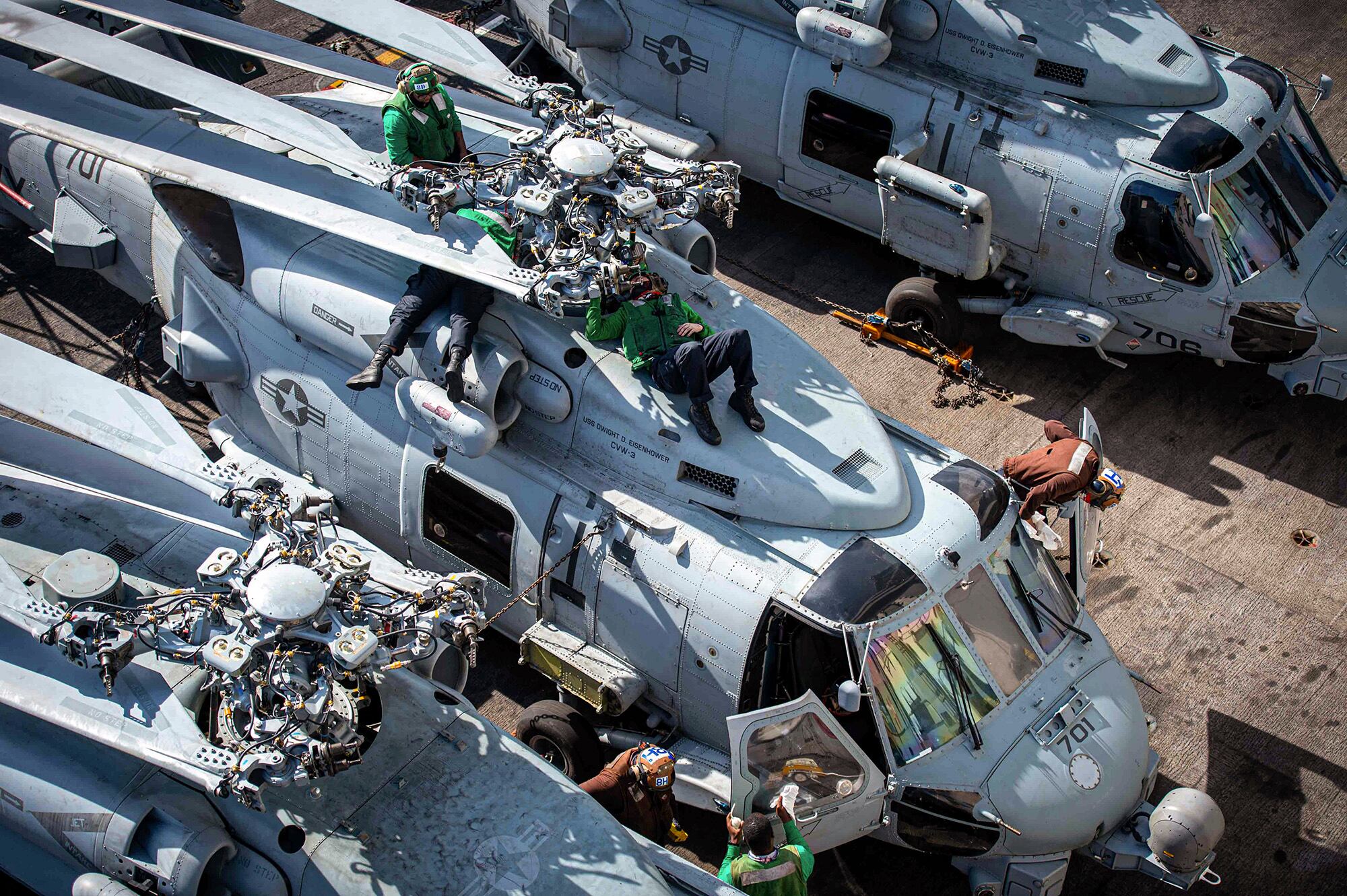 Sailors perform maintenance on an MH-60R Sea Hawk on Jan. 27, 2021, on the flight deck aboard the Nimitz-class aircraft carrier USS Dwight D. Eisenhower (CVN 69) in the Atlantic Ocean.