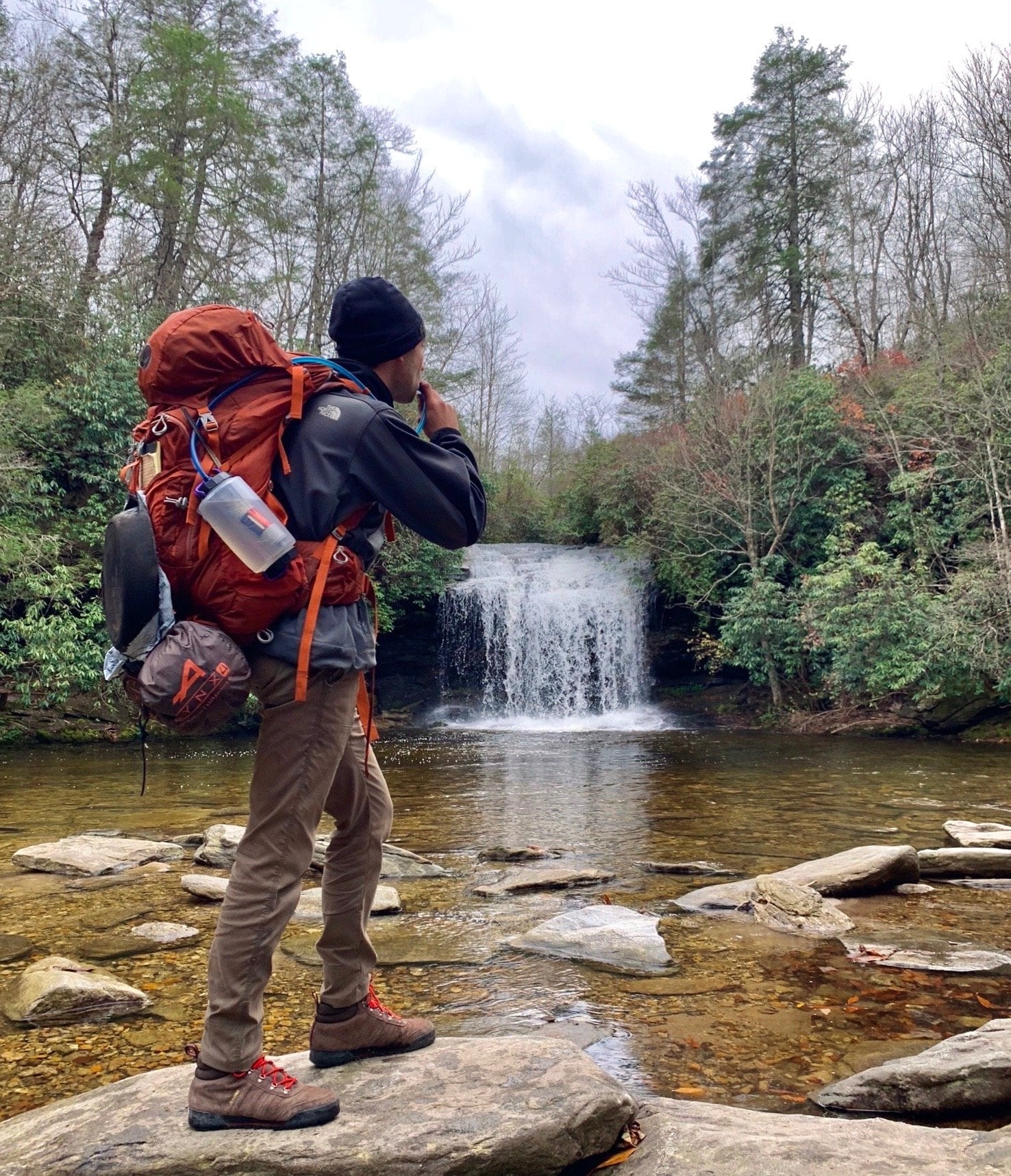 Hiker with backpack near waterfall