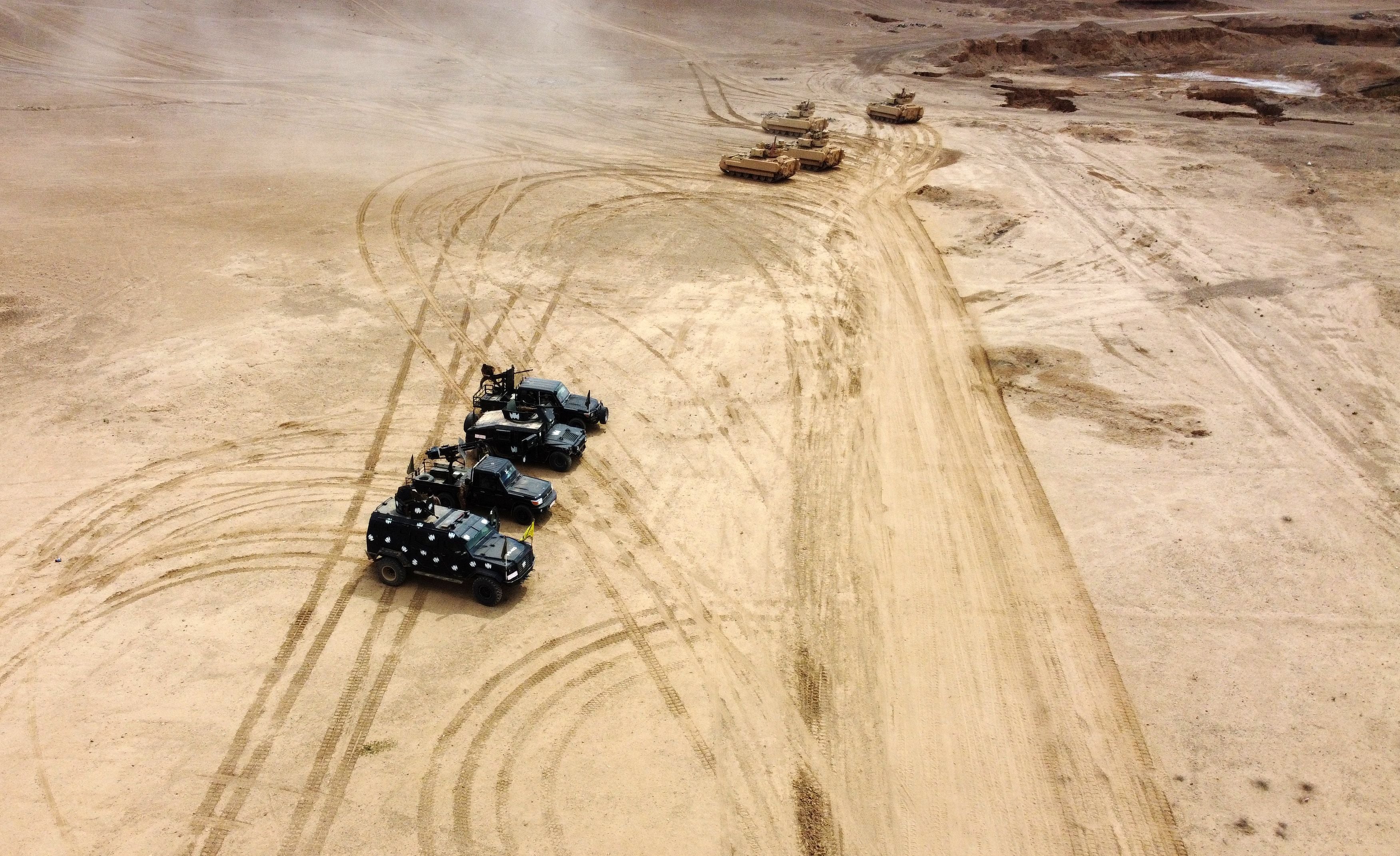 This aerial view shows troops from the Syrian Democratic Forces Special Operations and the US-led international coalition, take part in heavy-weaponry military exercises in the countryside of Deir Ezzor in northeastern Syria, on March 25, 2022.