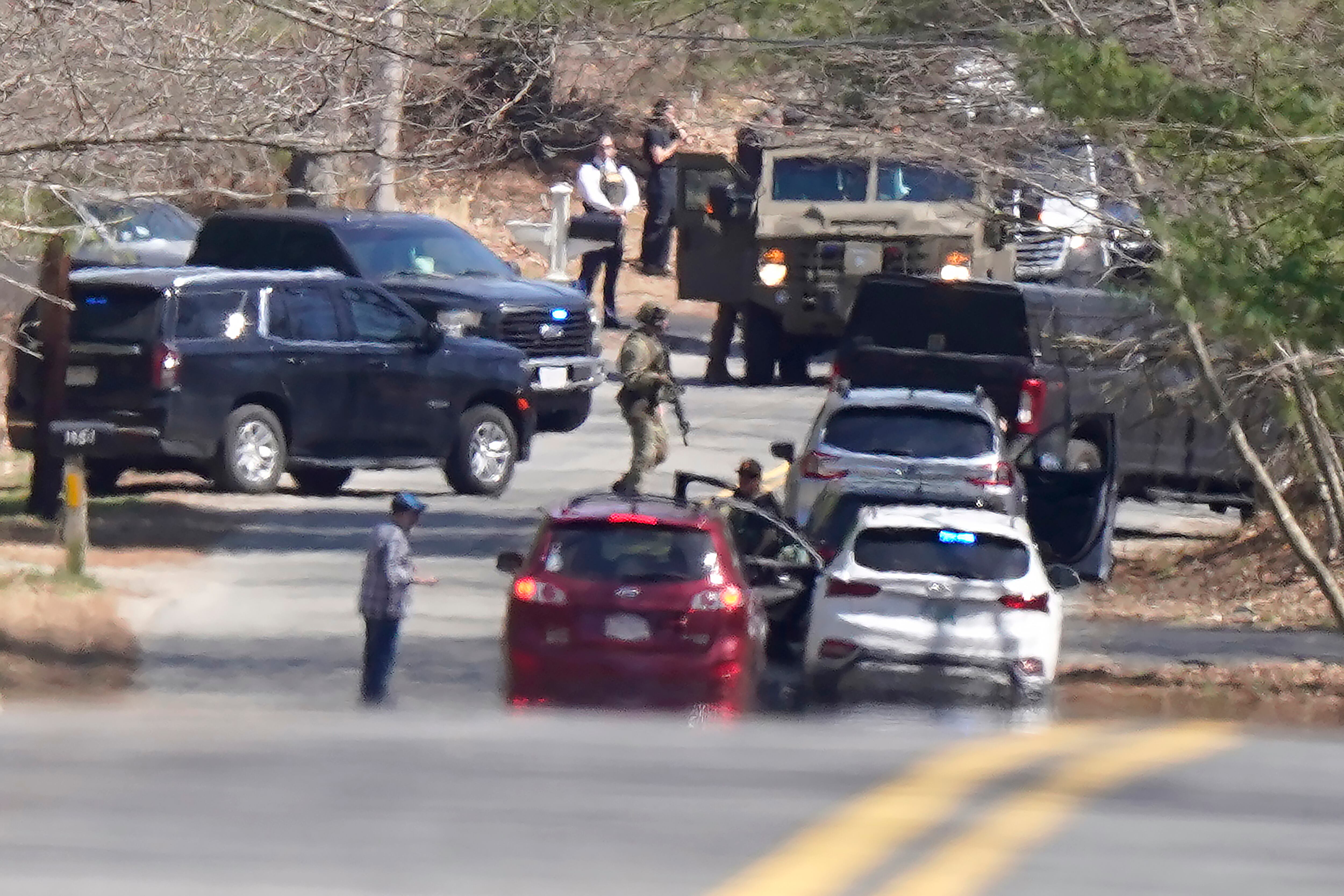 Members of law enforcement assemble on a road, Thursday, April 13, 2023, in Dighton, Mass., near where FBI agents converged on the home of a Massachusetts Air National Guard member who has emerged as a main person of interest in the disclosure of highly classified military documents on the Ukraine.