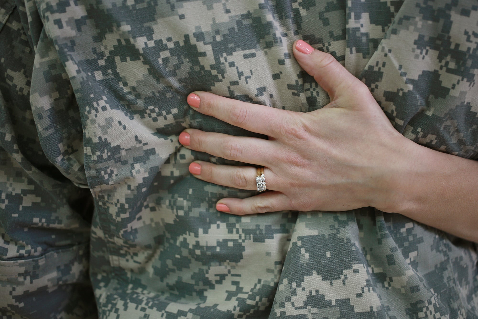 WO1 Anthony Woodmansee of the U.S. Army's 101st Airborne Division is embraced by his wife Emily Woodmansee during a homecoming ceremony at Campbell Army Airfield on March 21, 2015, in Fort Campbell, Ky.