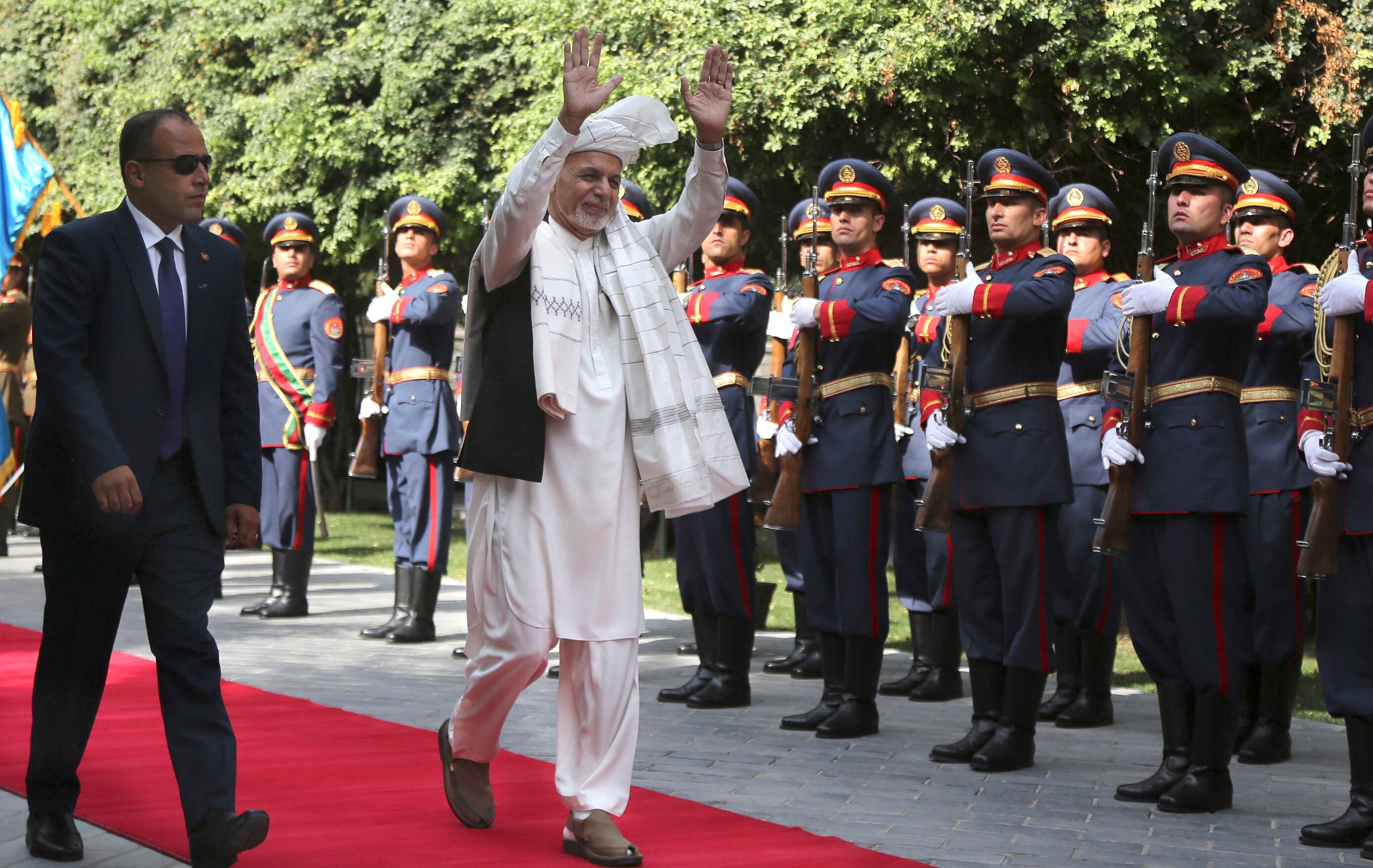 Afghanistan's President Ashraf Ghani, center, greets as he arrives to offer Eid al-Adha prayers at the presidential palace in Kabul, Afghanistan, Sunday, Aug. 11, 2019.