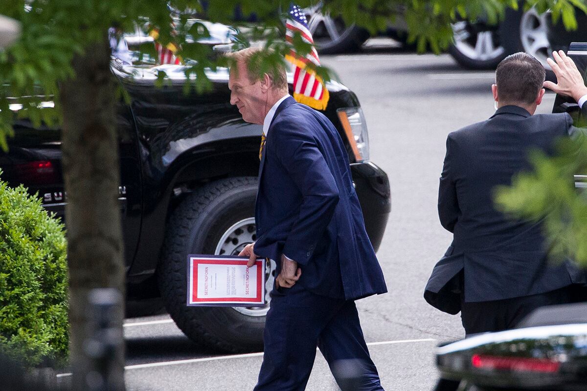 Outgoing acting Defense Secretary Patrick Shanahan arrives for a meeting with President Donald Trump about Iran carrying a folder marked secret