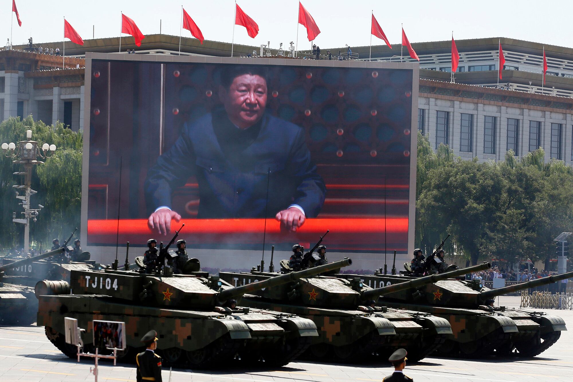 In this Sept. 3, 2015, file photo, Chinese President Xi Jinping is displayed on a screen as Type 99A2 Chinese battle tanks take part in a parade commemorating the 70th anniversary of Japan's surrender during World War II held in front of Tiananmen Gate in Beijing.