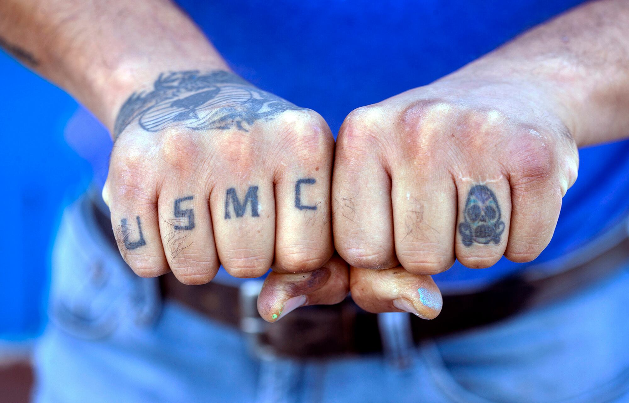 Veteran Cesar Lopez displays his USMC tattoos outside his home in Las Vegas