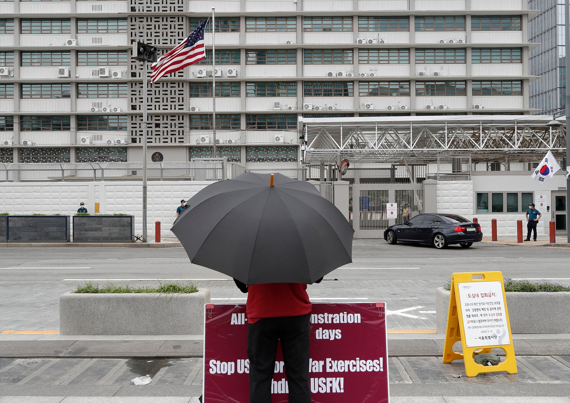 A man stands with a banner to oppose the joint military exercises between South Korea and the United States near the US Embassy in Seoul, South Korea, Sunday, Aug. 16, 2020.