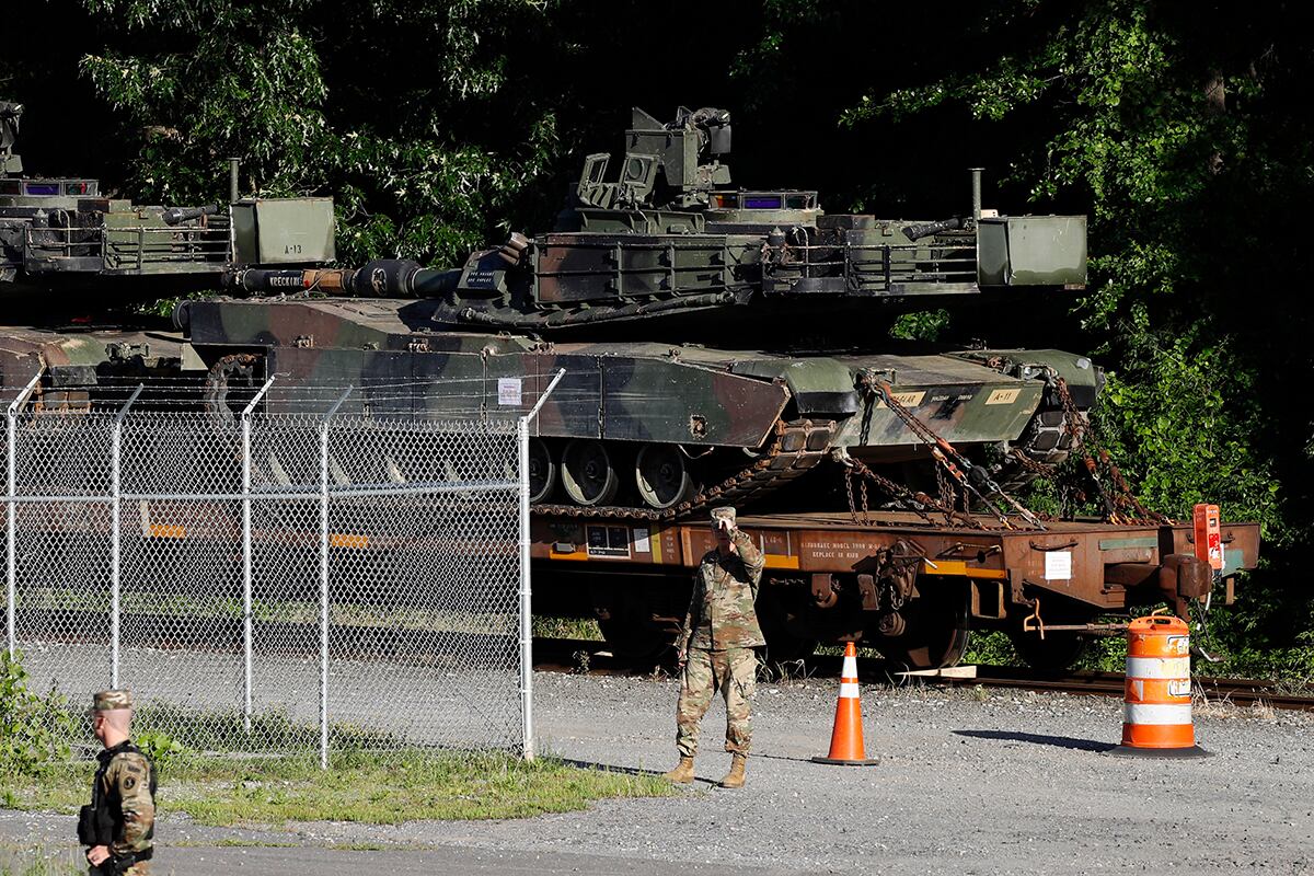 Military police walk near Abrams tanks on a flat car in a rail yard, Monday, July 1, 2019, in Washington, ahead of a Fourth of July celebration that President Donald Trump says will include military hardware.