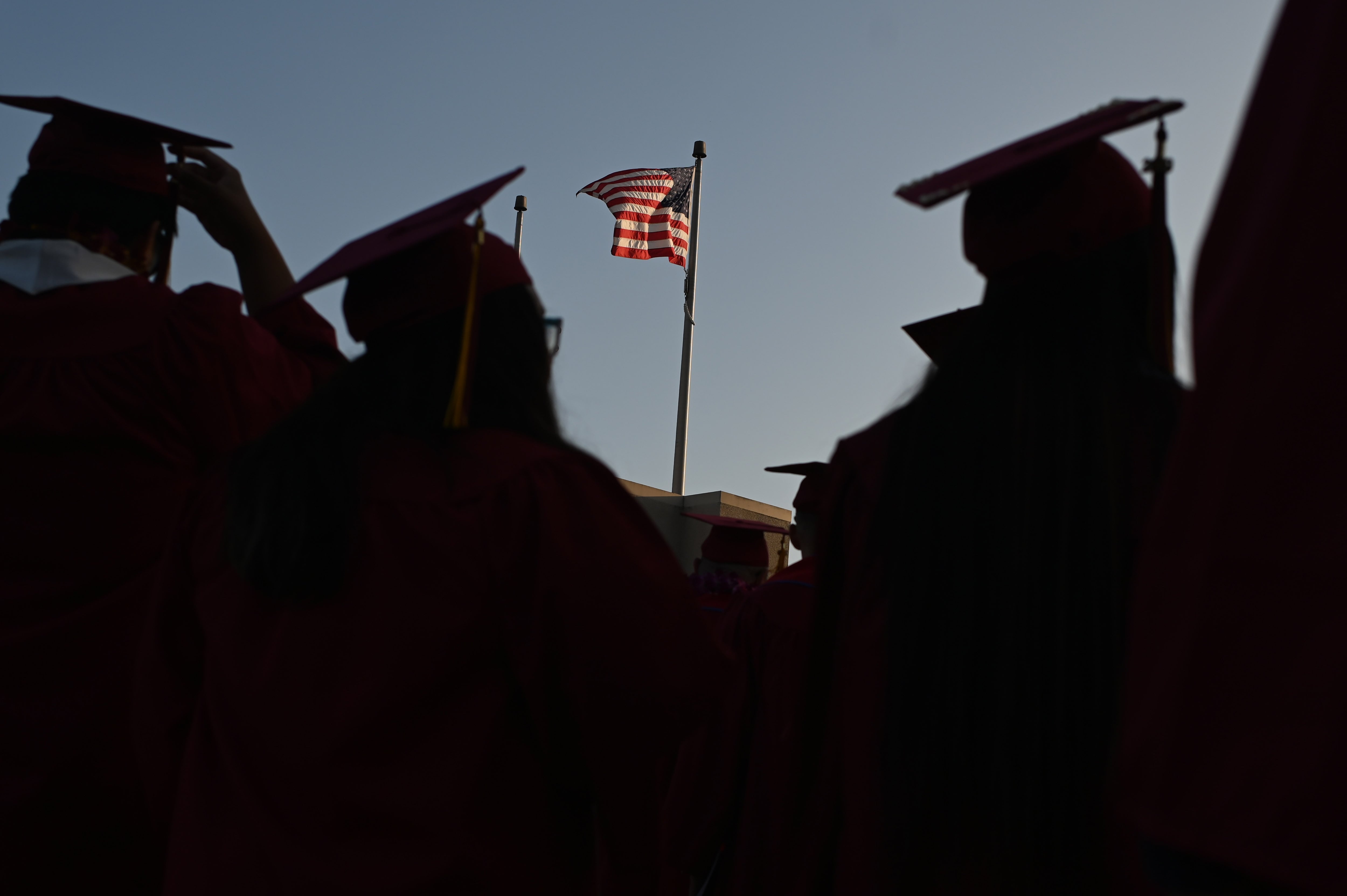 A US flag flies above a building as students earning degrees at Pasadena City College participate in the graduation ceremony, June 14, 2019, in Pasadena, California.