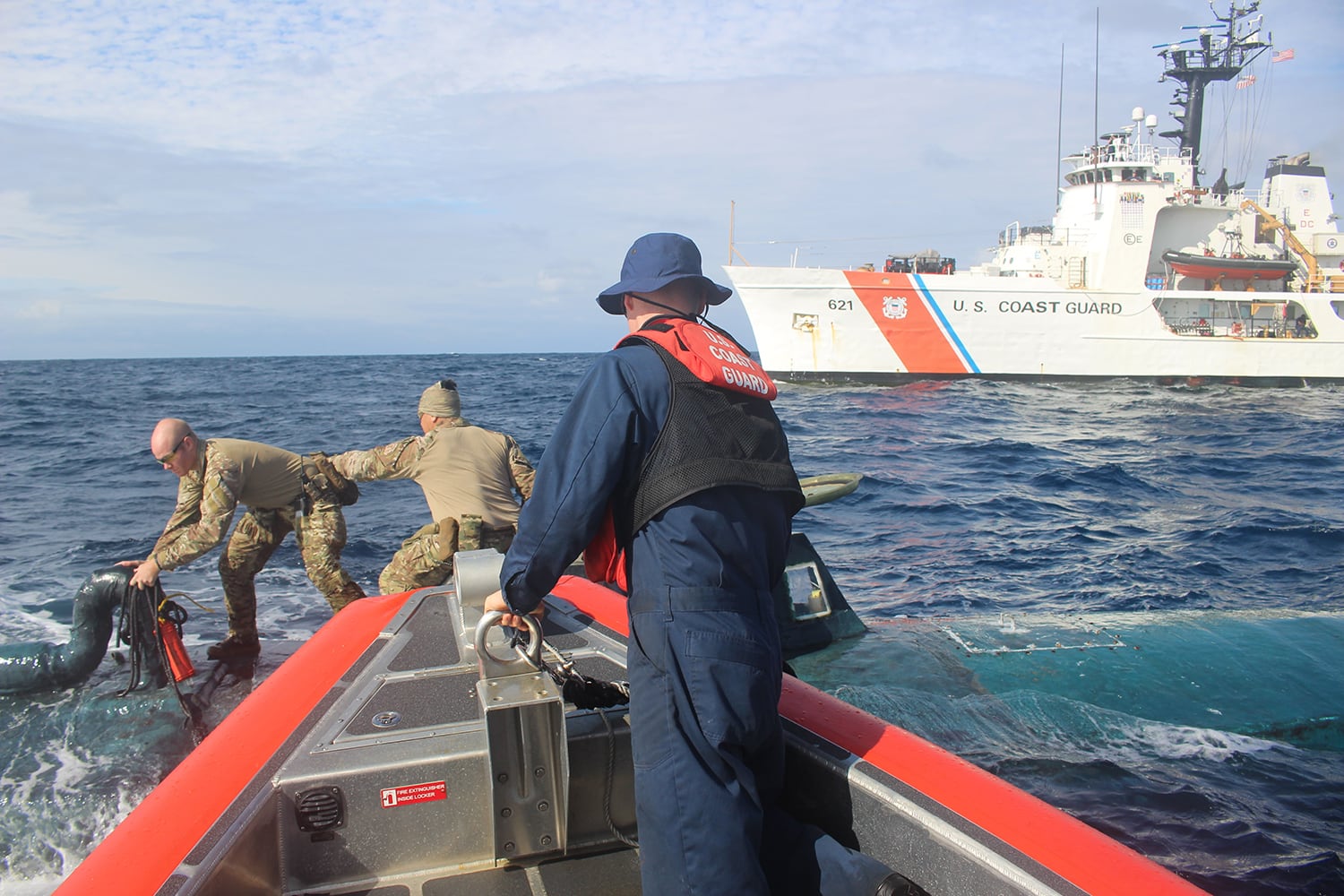 Coast Guard members board a narco semi-submersible